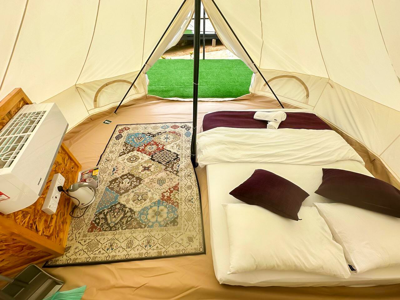 Une tente équipée d’un lit, d’un chauffage et d’un tapis.