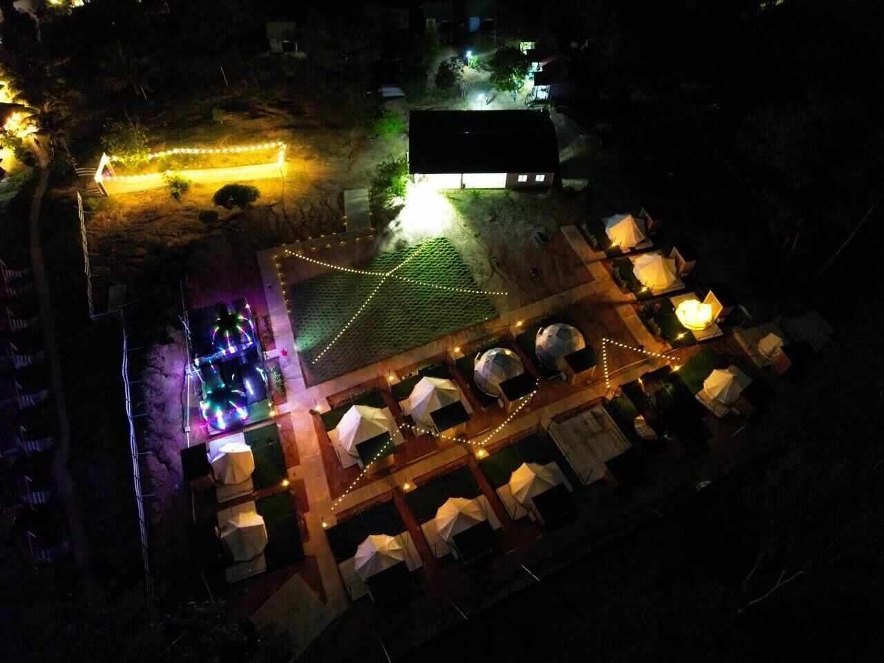 Een terras met tenten en lichtjes.