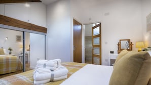 Een hotelkamer met een bed, een bureau, een stoel, een spiegel en een lamp.