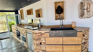 Una cocina moderna con una isla de madera, electrodomésticos integrados y un ventanal grande.