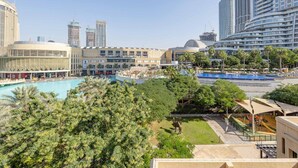 A hotel with a swimming pool, palm trees, and high-rise buildings in the background. - Tajer Residence Old Town Island 5038 Downtown (Dubai)