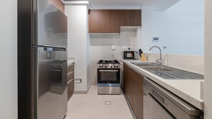 Une cuisine moderne dotée d’appareils électroménagers en acier inoxydable, de meubles en bois et d’un plan de travail en granit.