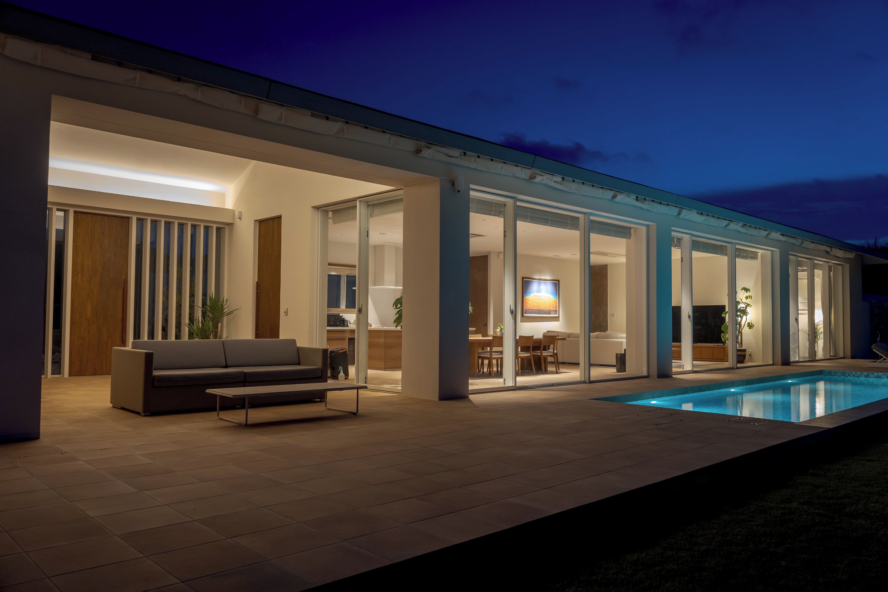 Una casa moderna con piscina, un espacio de estar abierto y un comedor.