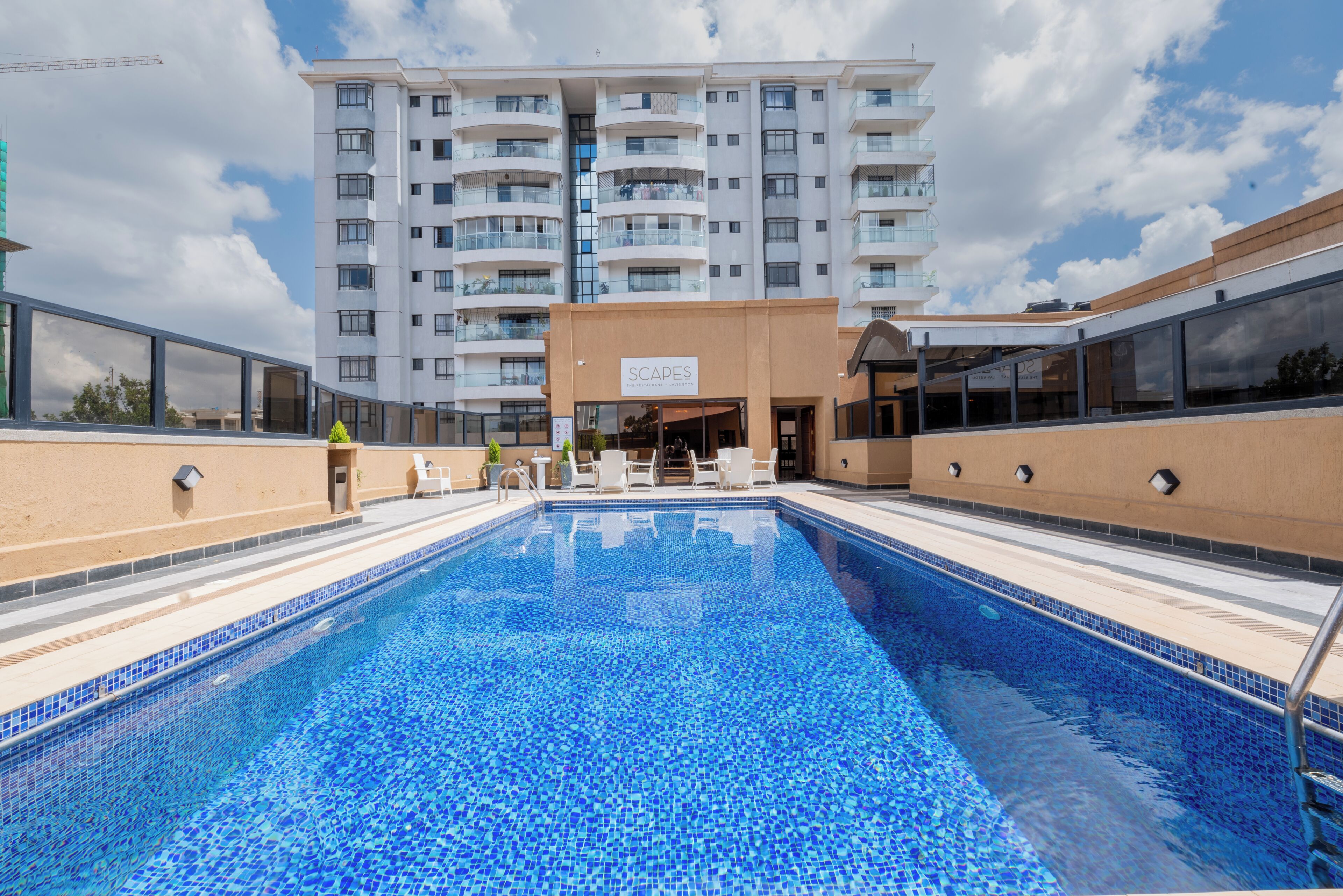 A swimming pool with a view of a multi-story building in the background.