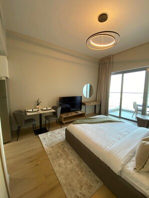 Relax in a spacious room with a large bed, flat-screen TV, and city view.