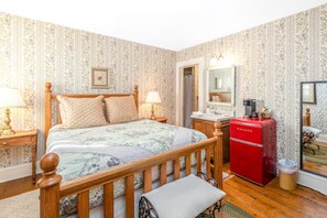 Relax in a traditional bedroom with a four-poster bed, bedside table, and bench at the foot of the bed.