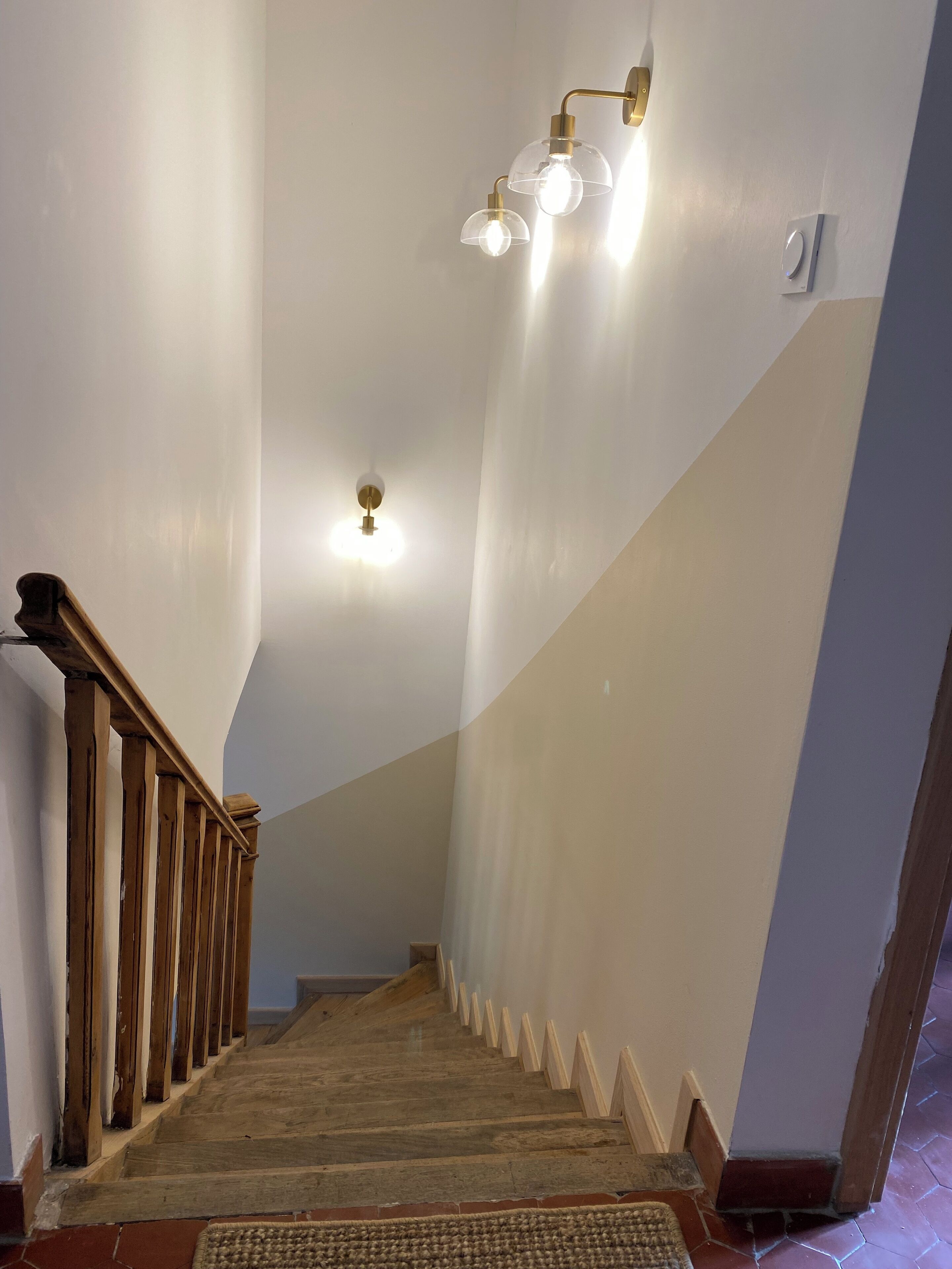 A staircase with wooden railings and a carpeted landing.