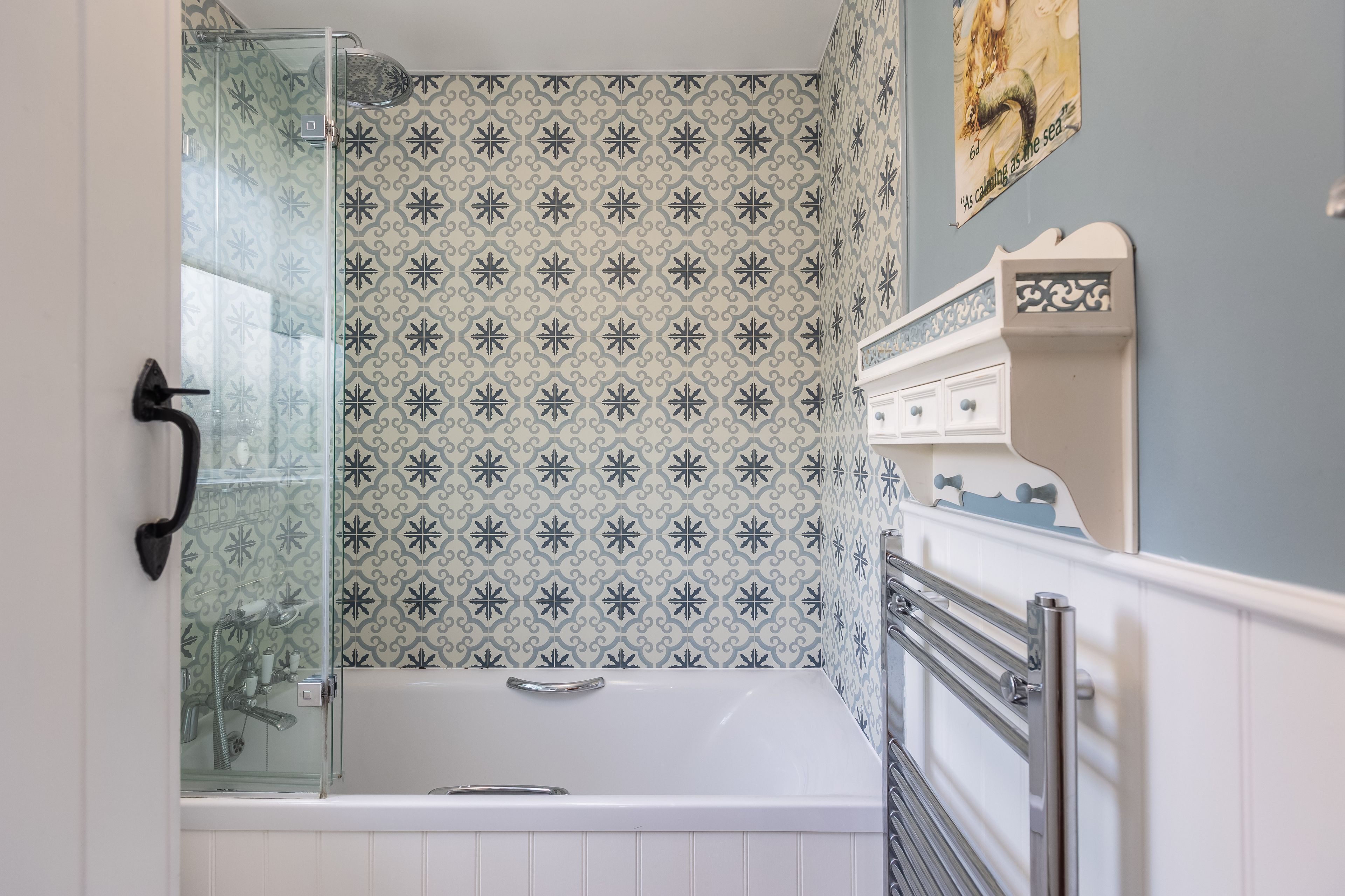 A bathroom with a shower, a bathtub, and a vanity with drawers.