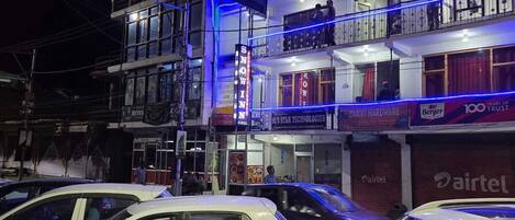 A multi-story building with balconies, a restaurant named 'SNOWIN,' and a '100 YEARS OF TRUST' sign.