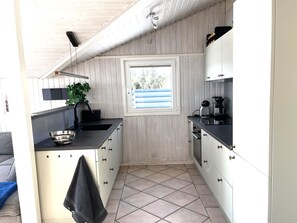 A compact kitchen with a window, a sink, and a coffee maker.