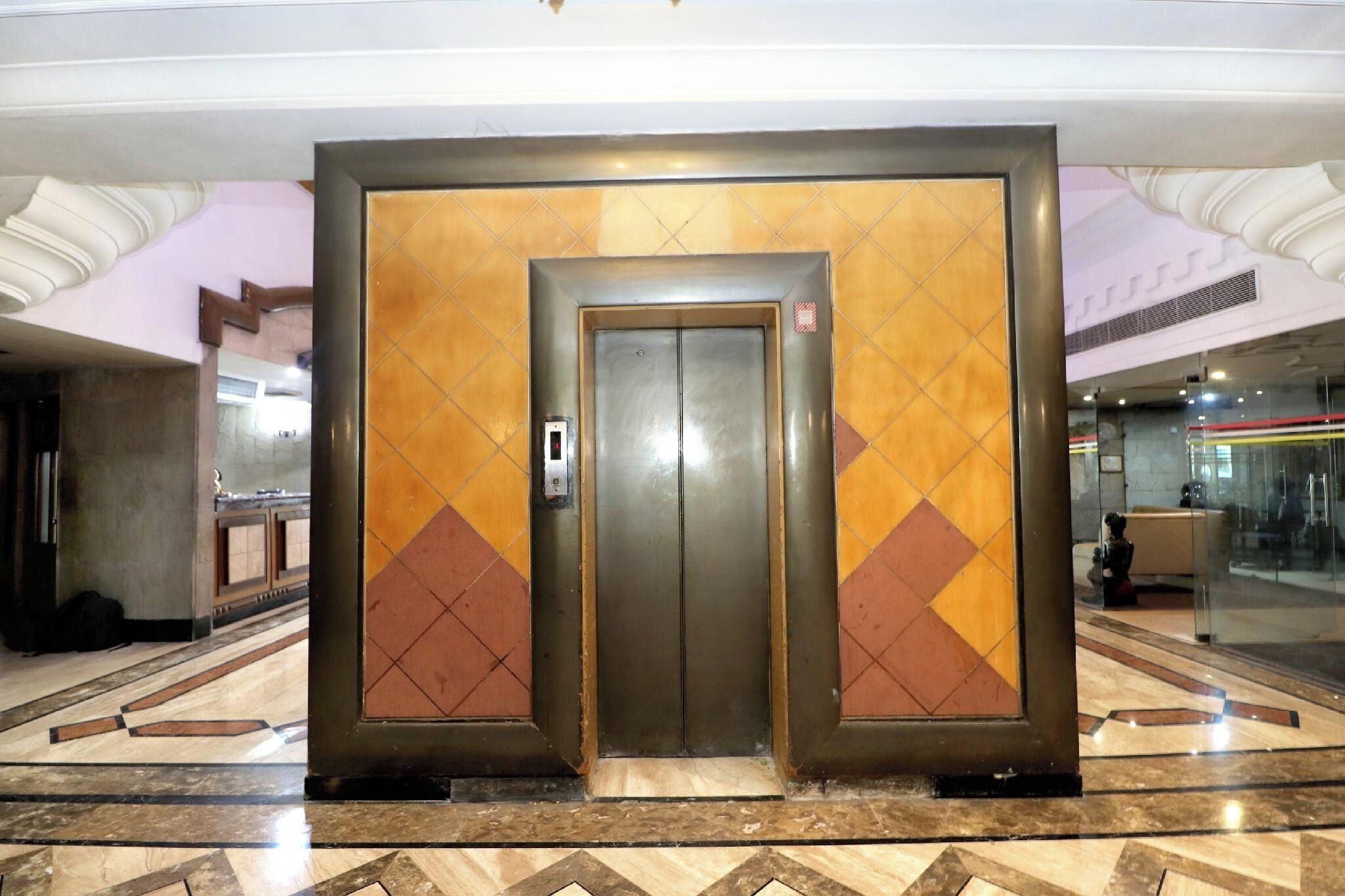 An elevator with a metallic finish and a patterned door design.