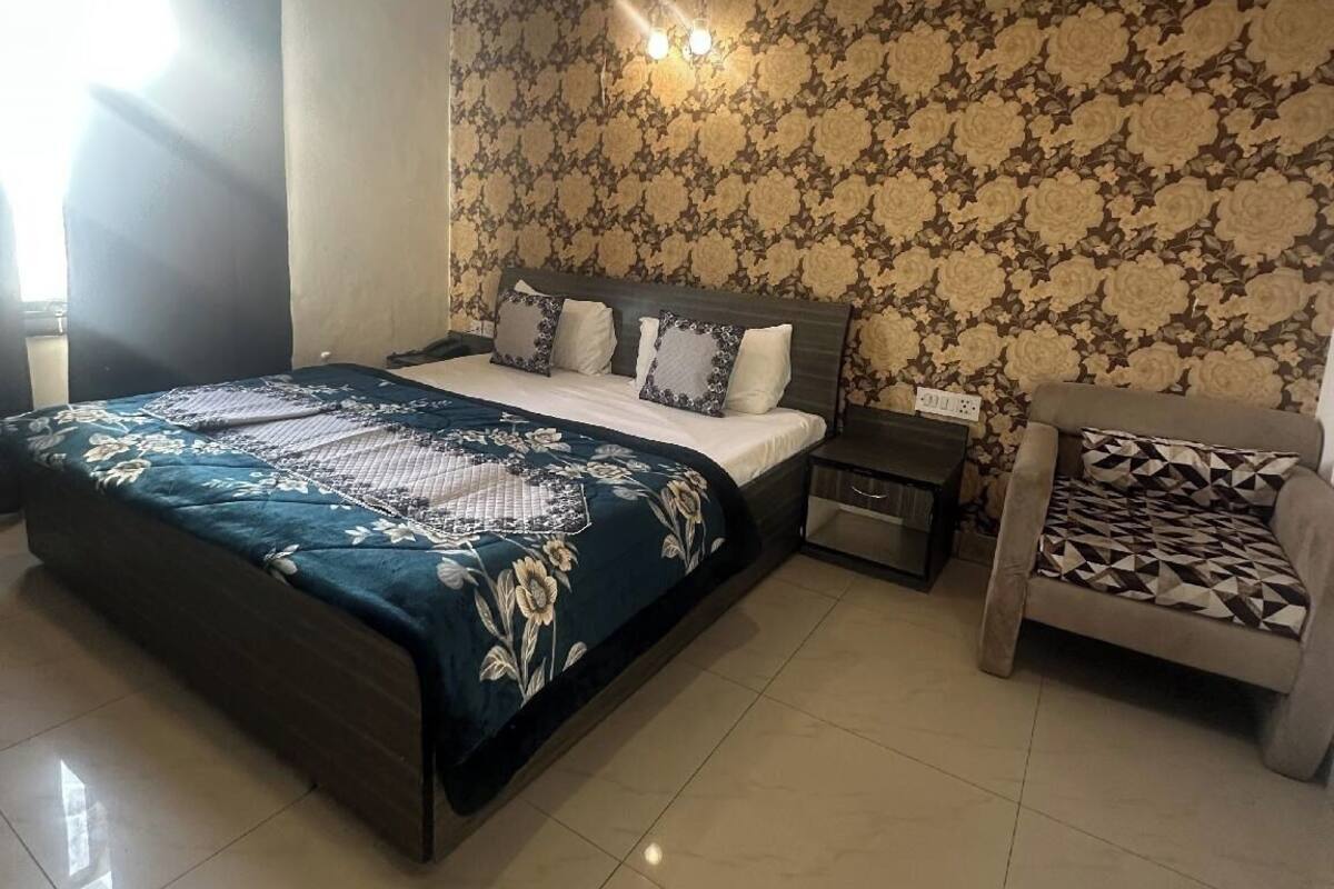 Un dormitorio con cama, mesita de noche y silla.