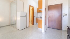 A modern kitchen with a refrigerator, wooden cabinets, and a sink. - Anagnina residence, 400m from Metro A (Roma)