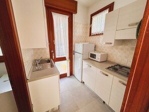 Kylskåp, mikrovågsugn, spishäll och grytor/köksredskap