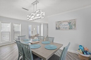 Une salle à manger avec une table en bois, des chaises bleues et un luminaire décoratif.