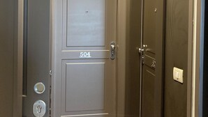 Un couloir avec une porte portant l’inscription « 504 » et un interrupteur sur le mur.