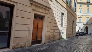 Un bâtiment doté d’une grande porte en bois, situé dans une rue pavée, avec des vélos garés devant.