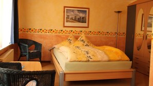 A bedroom with a bed, a chair, a table, and a wardrobe. - Studio '3' with Shared Terrace (Bamberg)