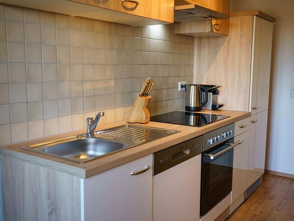 Een koelkast, een oven, een kookplaat, een vaatwasser