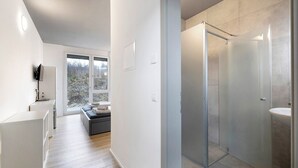 A modern bathroom with a glass shower enclosure, a sink, and a toilet. - Room '5' with Shared Terrace and Wi-Fi (Dußlingen)
