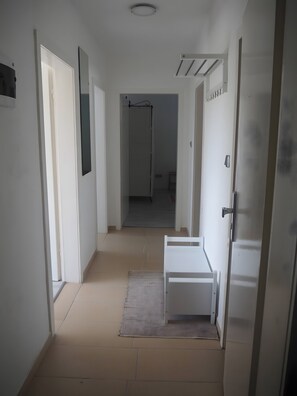 A narrow hallway with white walls, a tiled floor, and a door on the right. - Apartment '4' with Shared Terrace, Shared Garden and Wi-Fi (Gerstungen)