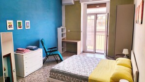A bedroom with a bed, a desk, a chair, a wardrobe, and a window. - Art house - Central station (Napoli)