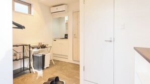 A compact hotel room with a kitchenette, a small dining area, and a bathroom.