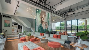 A spacious living area with a large sofa set, a staircase, and a mural on the wall. - Mandala Oasis (Bali)