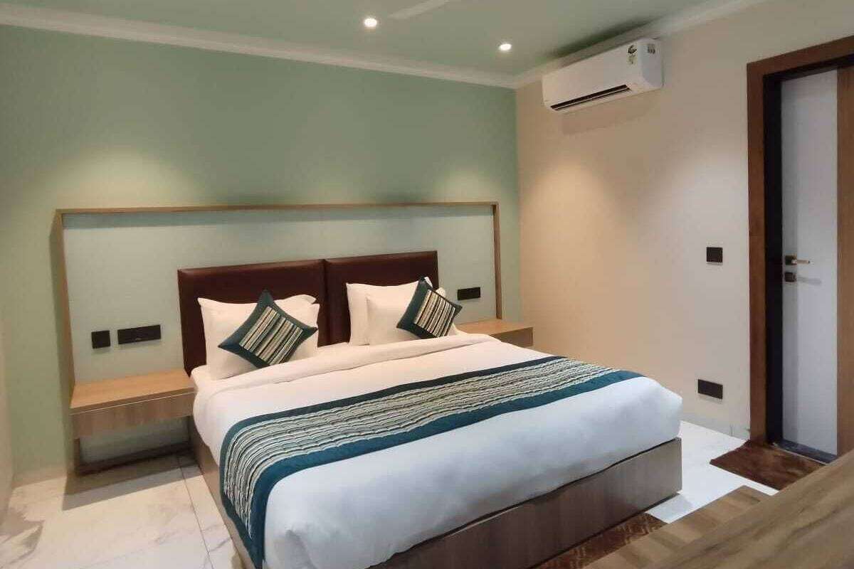 A modern bedroom with a bed, nightstands, a ceiling fan, and an air conditioning unit.