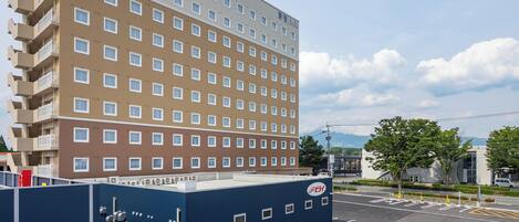 A multi-story hotel with a modern design, featuring a flat roof and a series of balconies.