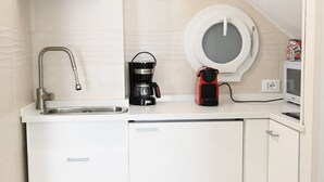 A compact kitchen with a sink, coffee maker, and microwave. - Spacious, luxury apartment with a view of the Duomo, accommodating 2+2+2 guests with privacy; rooftop elevator and Wi-Fi  (Firenze)