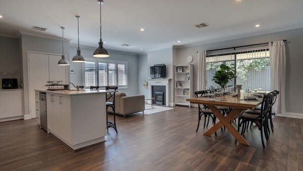 Enjoy a spacious open-plan layout with a central kitchen, dining space, and cozy seating area.