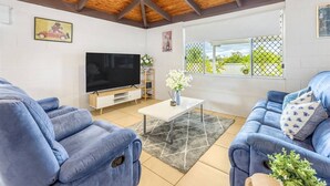 Un salon équipé d’un téléviseur, de deux canapés, d’une table basse et doté d’un plafond en bois.