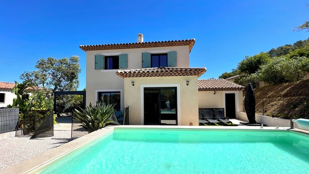 Ein zweistöckiges Haus mit Pool davor.
