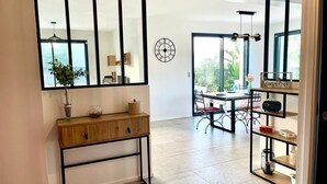 Eine moderne Küche mit einem Holzkonsolentisch, einem großen Spiegel und einem Essbereich mit Tisch und Stühlen.