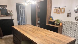 A modern kitchen with a wooden island, bar stools, and a hanging light fixture. - Spacious country house, 15 min from Bordeaux city center (Latresne)