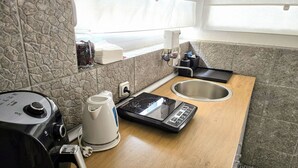A compact kitchen with a stone backsplash, a coffee maker, a toaster, and a sink. - Room-angelina Apartment 3 (Belgrade)