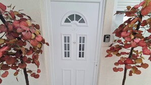 A white door with a small window and a decorative arch. - Room-angelina Apartment 3 (Belgrade)