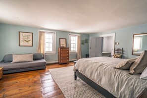 Une chambre à coucher comprenant un lit, un canapé, une commode et une chaise.