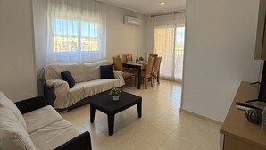 A modern living room with a sofa, a coffee table, and a dining area. - CB250 - Cala Blanca II, Superior - ServHouse (Orpesa)