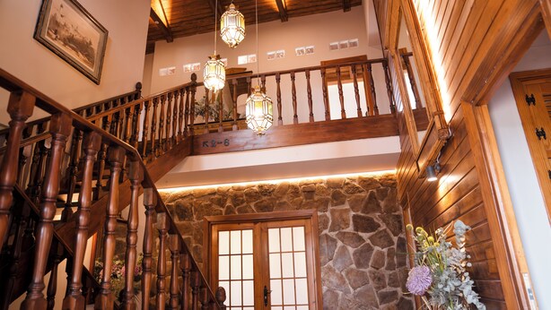 A wooden staircase with a stone wall and a wooden door.