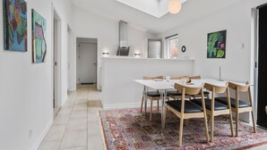 A modern kitchen with white cabinetry, a built-in oven, and a window above the sink.