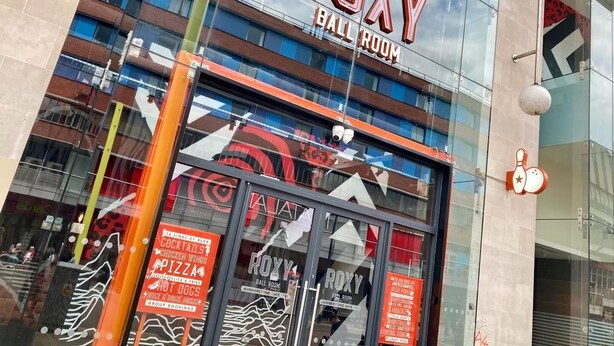 L’extérieur du Roxy Ball Room se distingue par une enseigne bien visible, de grandes fenêtres et une architecture moderne.