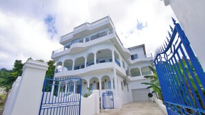 Un edificio de varios pisos con fachada blanca y puertas azules.