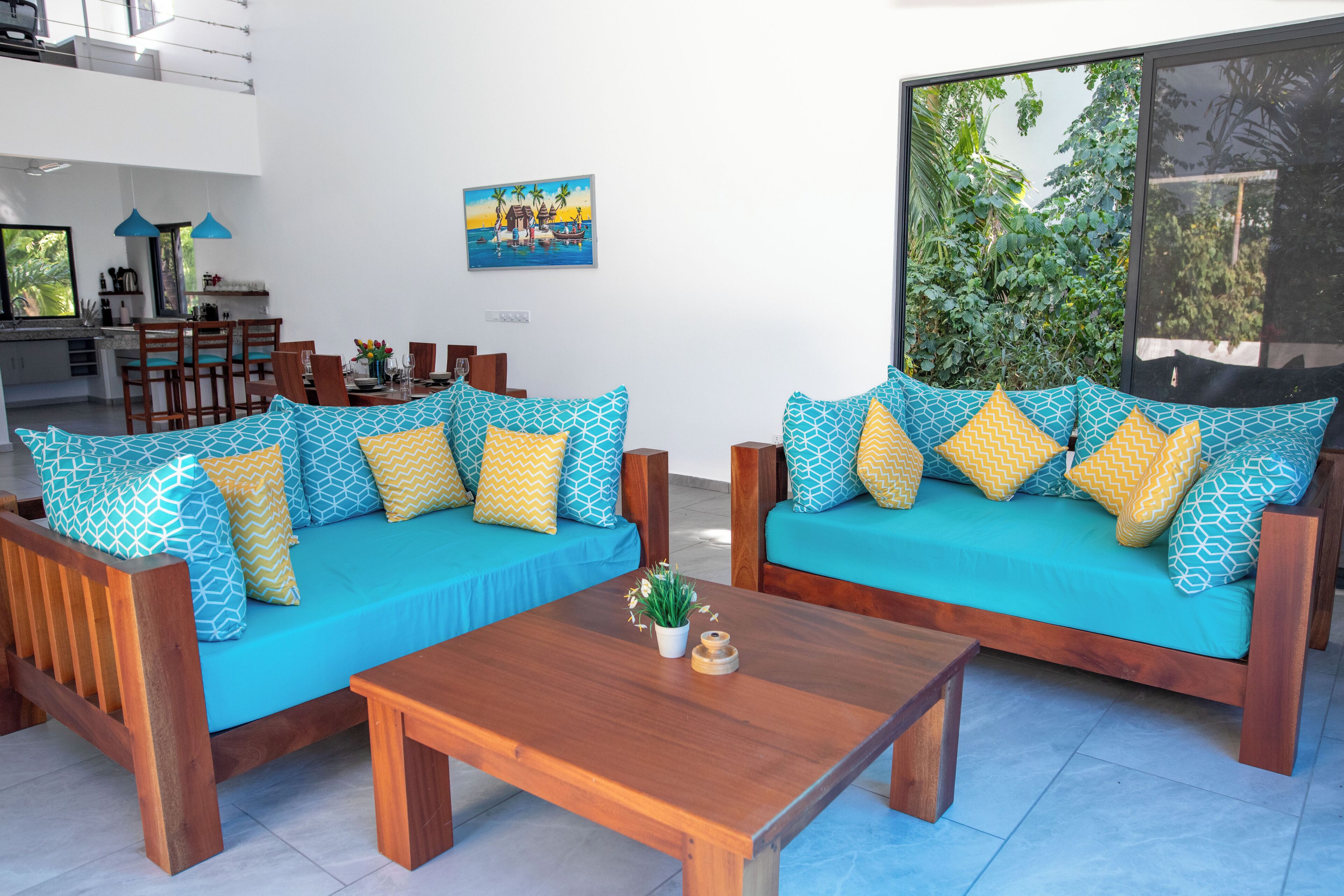 A modern living room with two sofas, a wooden coffee table, and a dining area with chairs and a table.