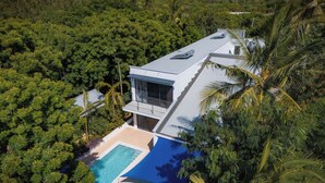 A modern house with a swimming pool surrounded by dense tropical vegetation. - Coral Reef Villas (Watamu)