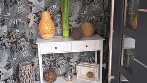 A white console table with wicker baskets and a woven vase against a floral wallpaper backdrop. - Vacation apartment Ernebibbel - comfortable apartment with terrace (Altendiez)