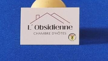 Un tavolo da biliardo con diverse palle colorate e un cartello con su scritto "L'Obsidienne Chambre d'Hôtes".