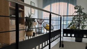 Ein modernes Interieur mit einer Holzregal, einer schwarzen Geländer und einem großen Fenster mit Blick auf die Straße.