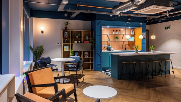 A modern interior with a bar area, seating, and a bookshelf.